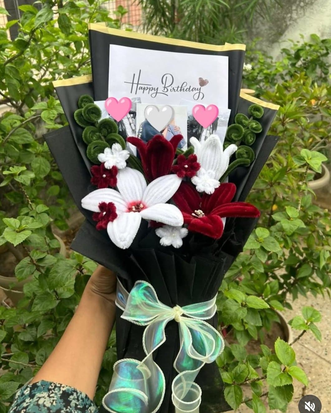 Pipe cleaner bouquet of white and maroon lilies with a Happy Birthday card and photos, in black paper