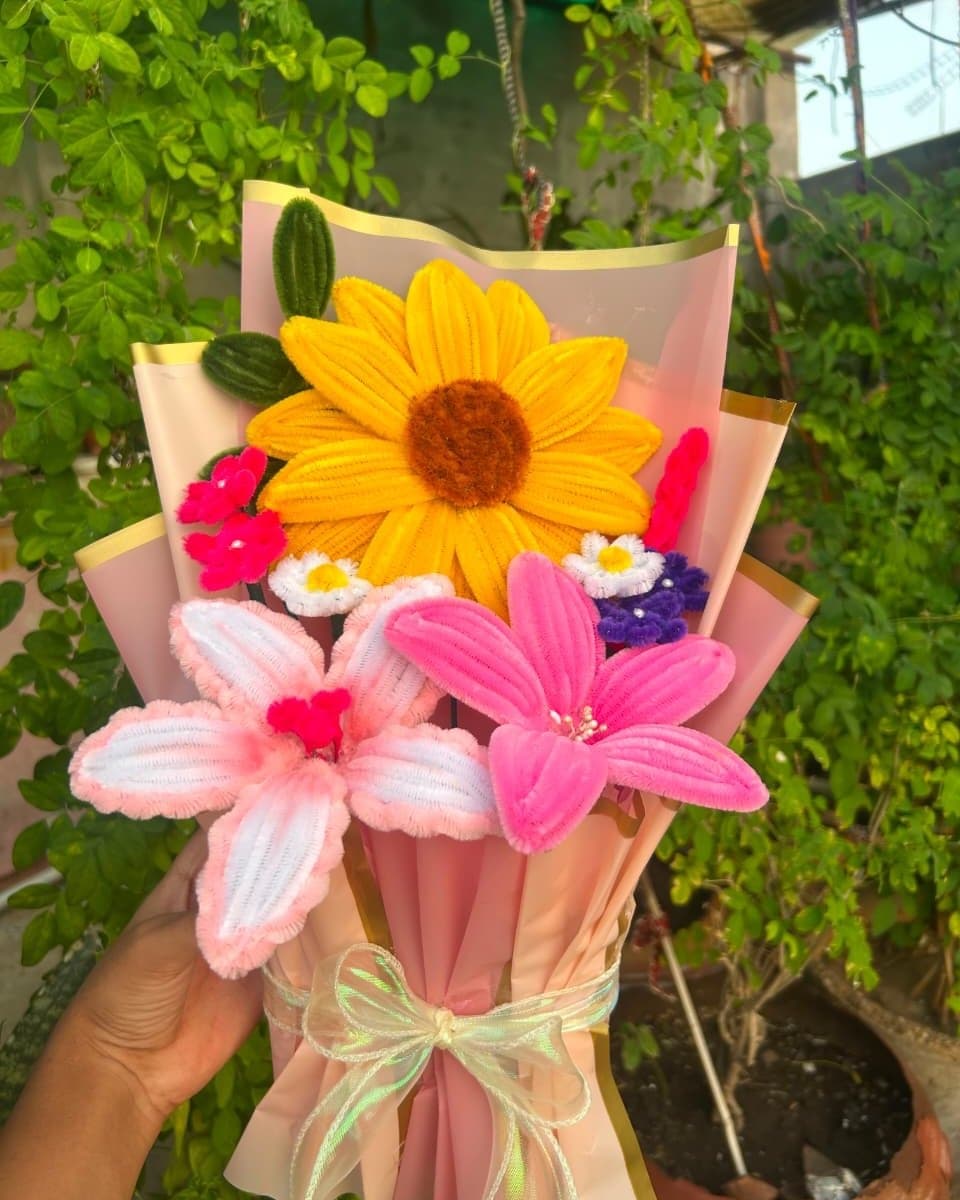 Pipe cleaner bouquet with a yellow sunflower, a hot pink lily, a white and pink lily and small blossoms
